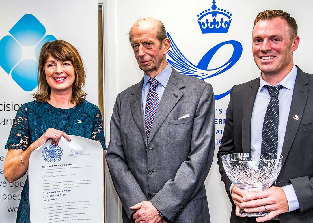 three people stood holding awards